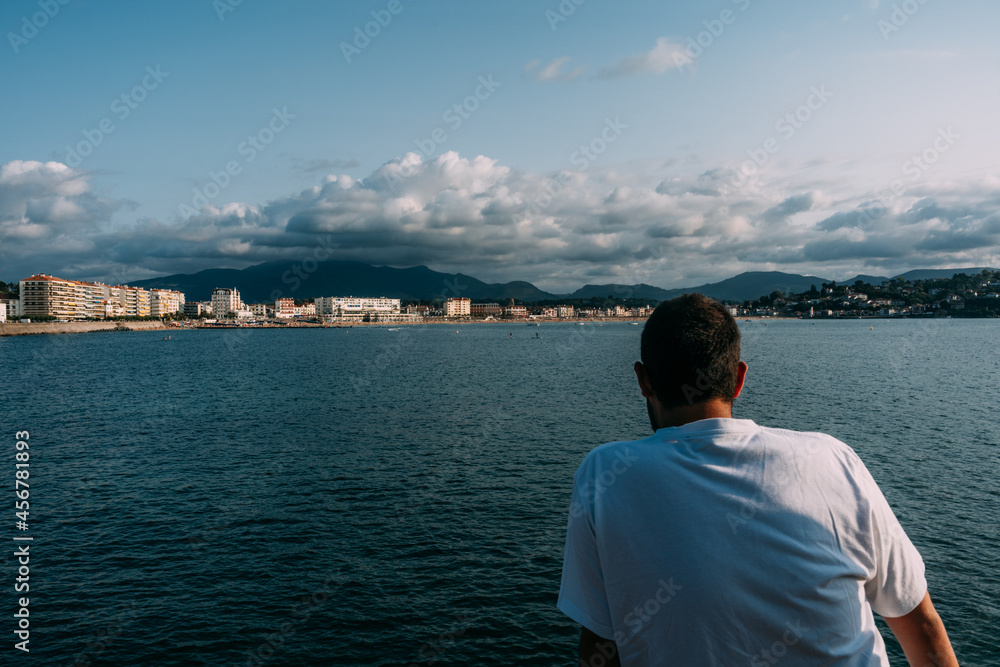 Unrecognizable traveler admiring sea and ridge under cloudy blue sky Unrecognizable traveler admiring sea and ridge under cloudy blue sky