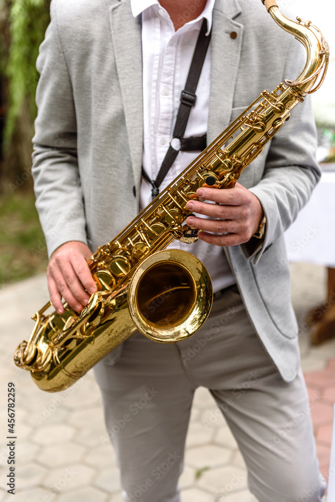 Obraz premium Saxophonist with saxophone prepares to perform at the holiday