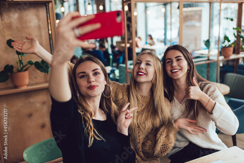 Expressive young women taking selfie and actively gesticulating