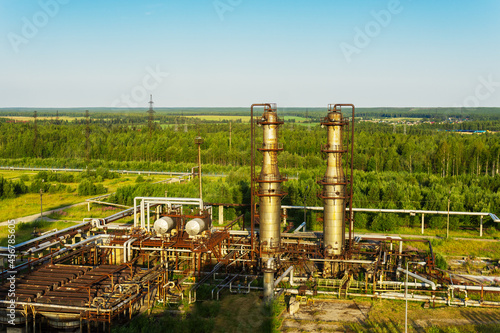 Fotografija Two old absorption columns of gas refueling against the background of a summer landscape