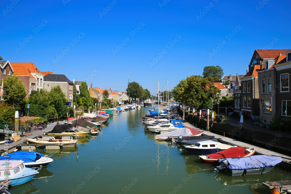 Dordrecht, Netherlands - July 9. 2021: View on water canal with inland yacht city harbor against blue summer sky