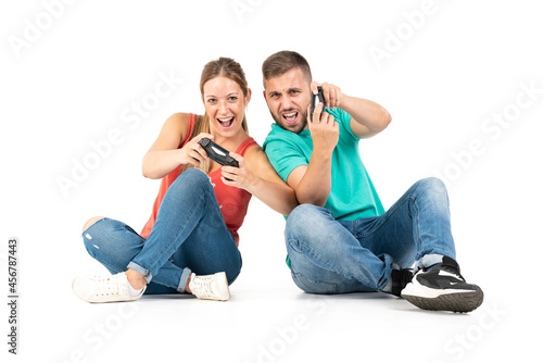 A young couple playing videogames with a controler on a white background photo