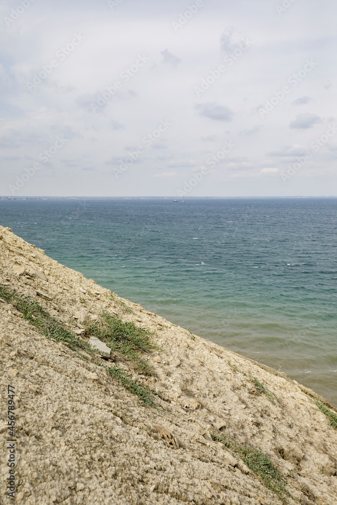 Hilly coast and blue expanse of the Black Sea. Cloudy weather at sea.