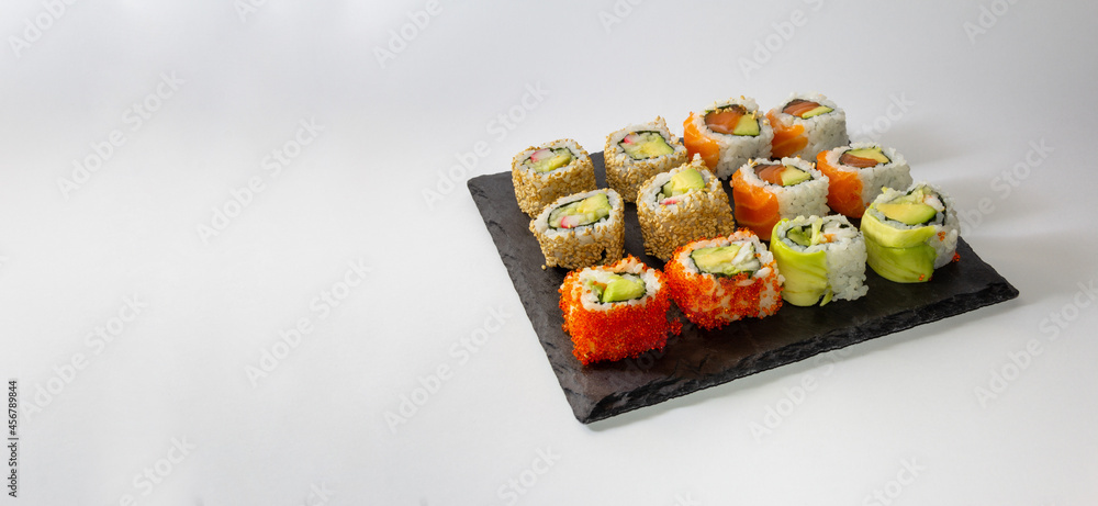 Sushi gourmet tray on slate surface on white background. Copy space. Selective focus. Sushi gourmet tray on slate surface on white background. Copy space. Selective focus.