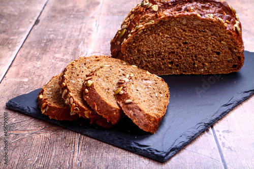 Freshly baked Pumpernickel boule rye bread on a slate serving platter photo