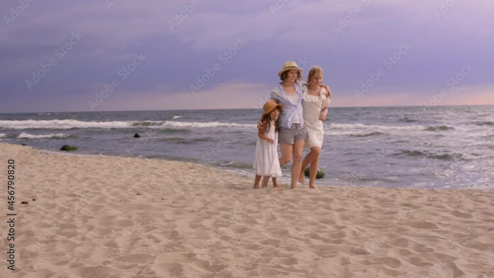 Pretty sisters daughters on the beach with smiling mother. Pretty sisters daughters on the beach with smiling mother.