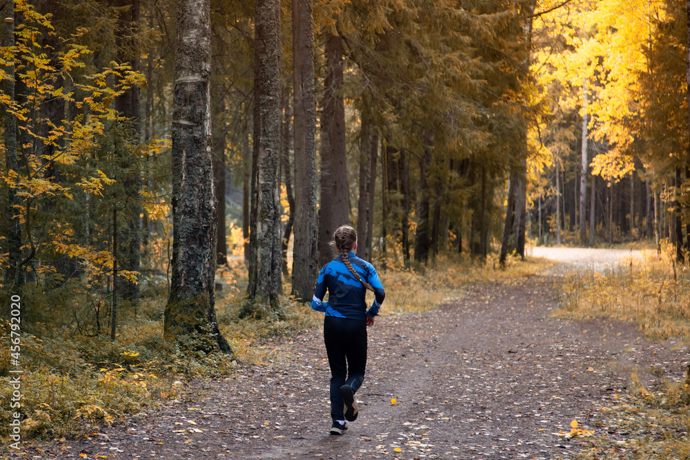 A woman is running in the forest, in the park.Fitness on the street.