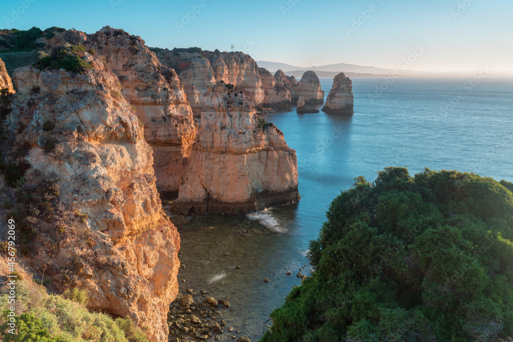 Sunny day in the Beach at Algarve, Portugal with turquoise sea in background. Bird eye view of the cliffs of Algarve. Aerial view. Concept for travel in Portugal and most beautiful places in Portugal.