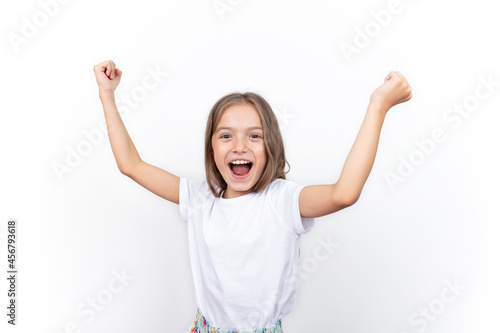 Child joy of success. Cute energetic little girl raising her arms excitedly. enjoy the victory, win. Isolated on white background.