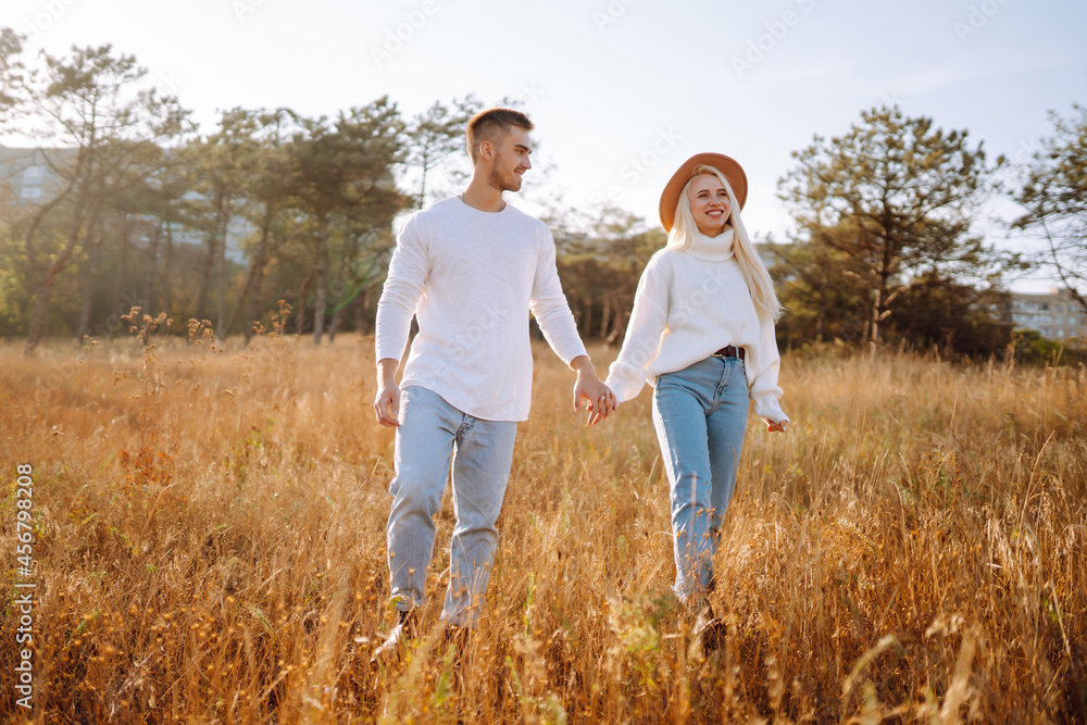 Young couple having fun walking and hugging during autumn sunny day. Enjoying time together. The concept of youth, love and lifestyle. Young couple having fun walking and hugging during autumn sunny day. Enjoying time together. The concept of youth, love and lifestyle.