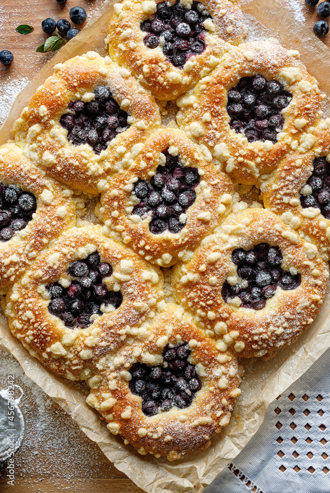 Traditional sweet yeast buns with the addition of blueberries and butter crumble, top view. Tasty homemade dessert Traditional sweet yeast buns with the addition of blueberries and butter crumble, top view. Tasty homemade dessert