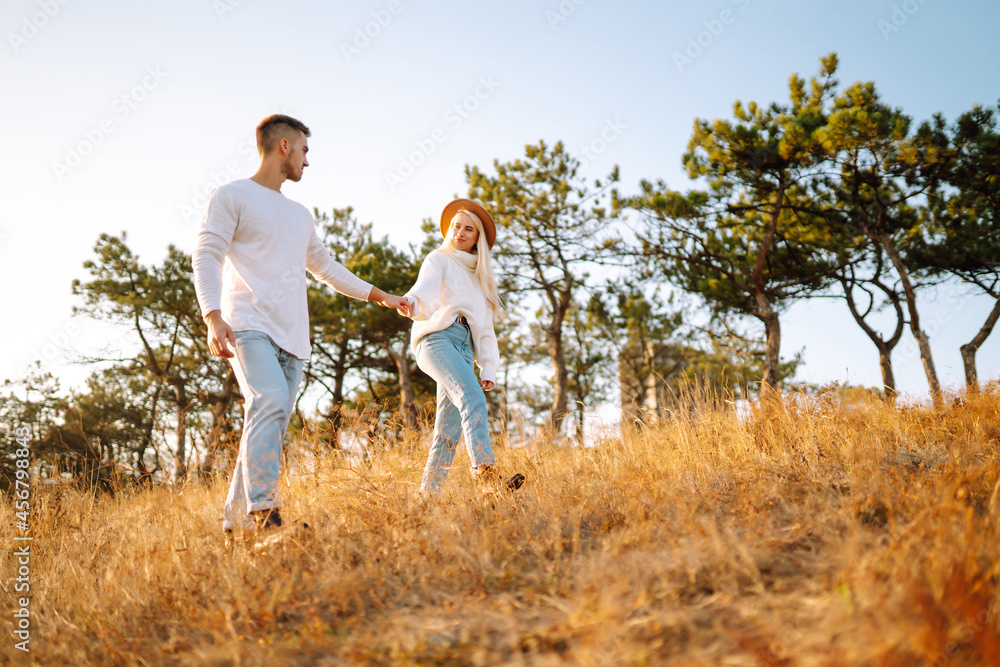 Young couple having fun walking and hugging during autumn sunny day. Enjoying time together. The concept of youth, love and lifestyle. Young couple having fun walking and hugging during autumn sunny day. Enjoying time together. The concept of youth, love and lifestyle.