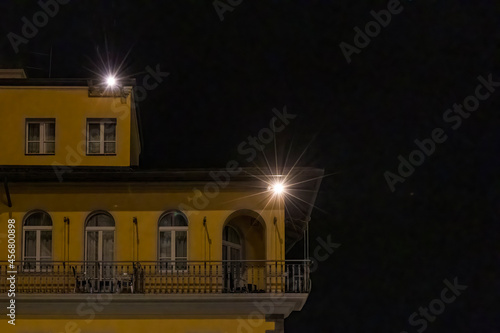 Illuminated apartment building facade with balcony at night in Riva del Garda on Lake Garda photo