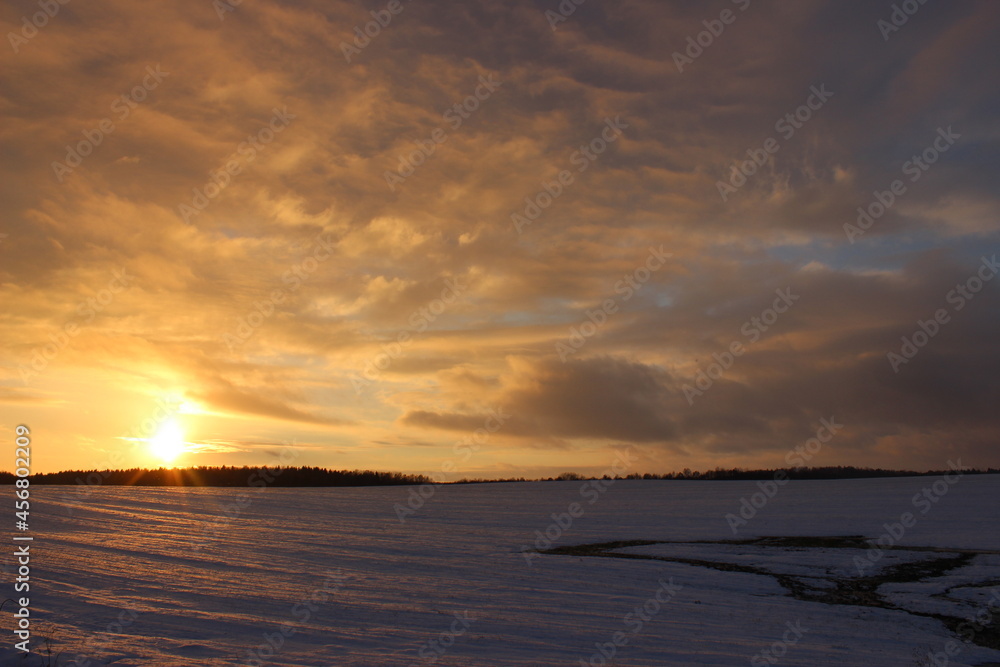 Winter landscape with a beautiful sunset over the field