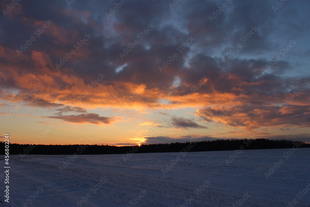 Winter landscape with a beautiful sunset over the field