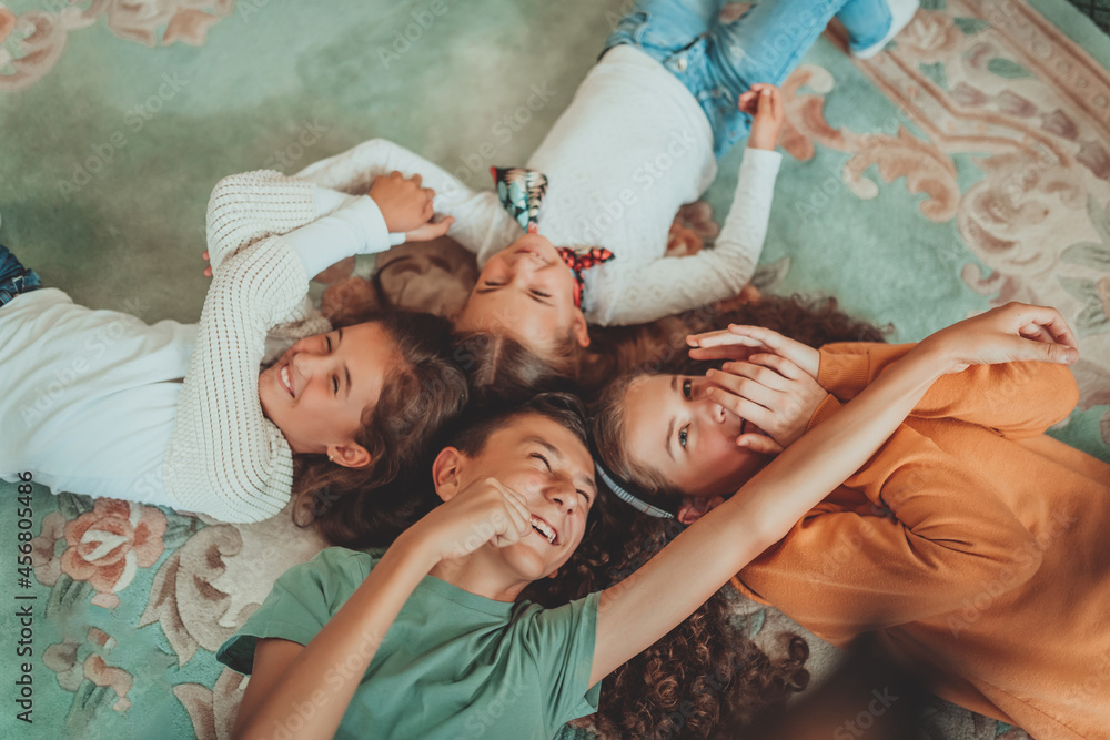 A happy group of friends have fun lying on the floor in a circle.Selective focus