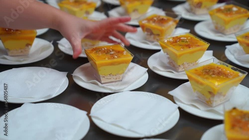 Catering. the waiter puts on the table kremenki with dessert and decorates.  photo