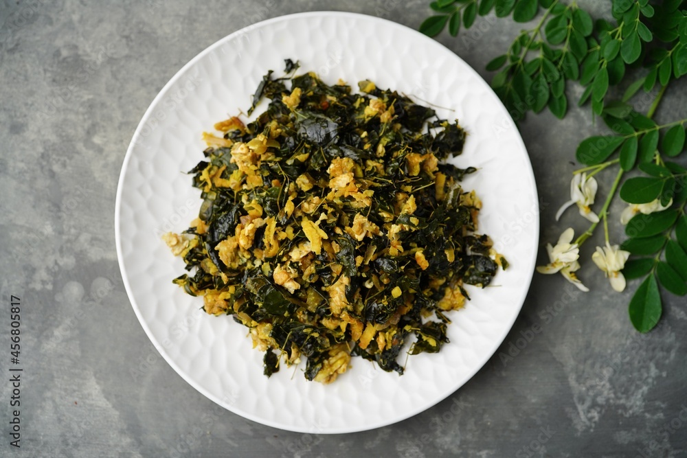 Moringa egg stir fry - healthy side dish with muringa leaves, selective focus Moringa egg stir fry - healthy side dish with muringa leaves, selective focus