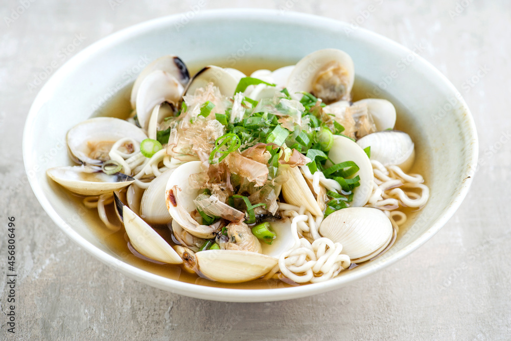 Traditional Japanese mussel ramen soup with noodles and bonito flakes served as close-up in a design bowl Traditional Japanese mussel ramen soup with noodles and bonito flakes served as close-up in a design bowl