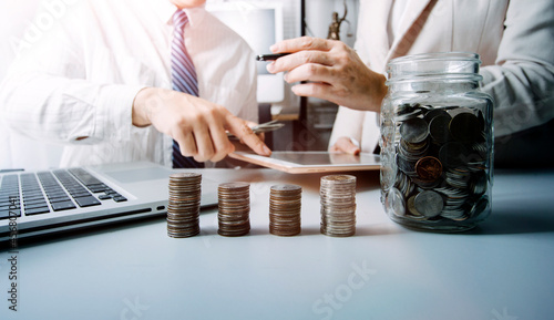 business people working at desk with piggy bank box.business finance saving and investment concept. hand put money coin into piggy bank for saving money wealth.