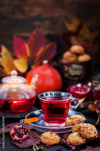 Glass cup of hot red tea and fresh homemade delicious apple cookies on rustic autumn background © kate_smirnova