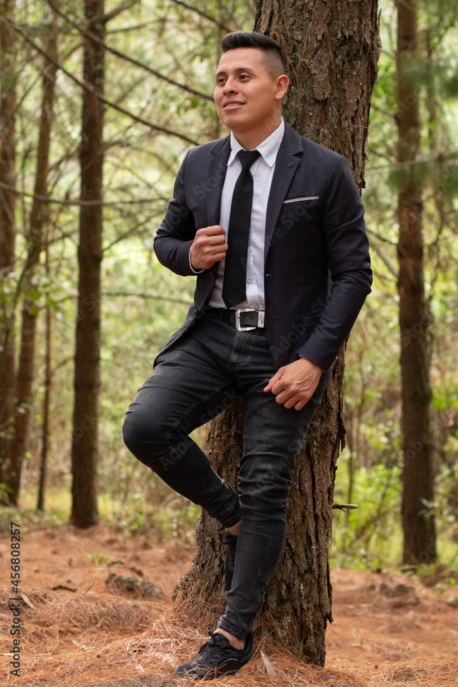 Latin man, elegant and attractive posing in a colorful forest. Latin man, elegant and attractive posing in a colorful forest.