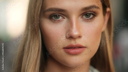 Closeup face of beautiful blond smiling woman with long hair. Portrait of gorgeous girl looking to camera