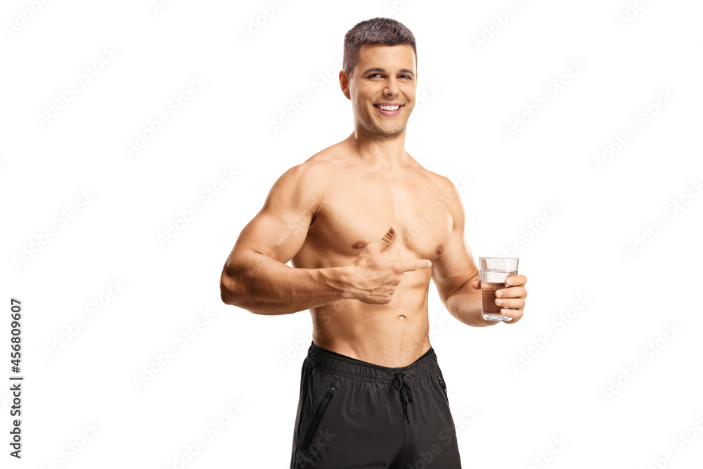 Shirtless muscular man holding a glass of water and pointing