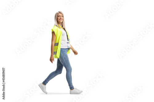 Full length profile shot of young female community worker wearing a safety vest and walking