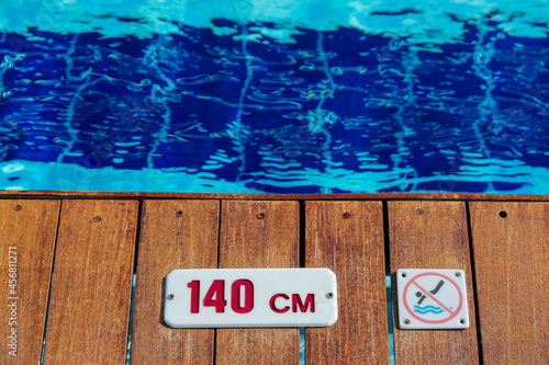 No diving and depth sign warning at swimming pool edge with copy space