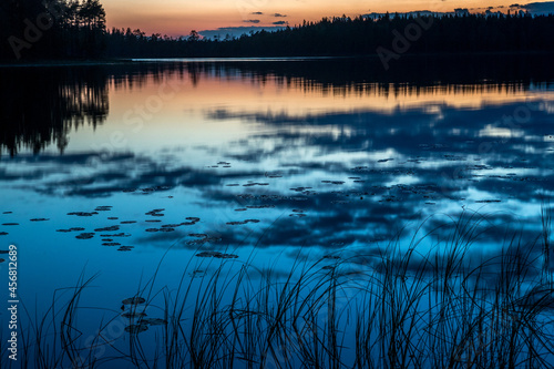 Evening over the lake. Dark blue sky. Night, forest, lake. © kareliatim