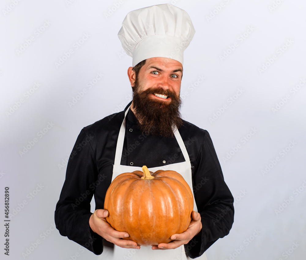 Male chef with pumpkin. Autumn vegetables. Pumpkin for Halloween. Diet food. Healthy vegetarian eating. Male chef with pumpkin. Autumn vegetables. Pumpkin for Halloween. Diet food. Healthy vegetarian eating.