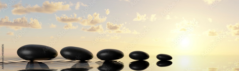 Row or line of black pebbles with water on sunset or sunrise background, zen, spa, yoga or meditation concept