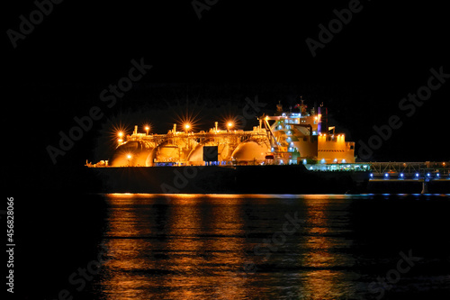 LNG tanker moored in the factory area at night. photo