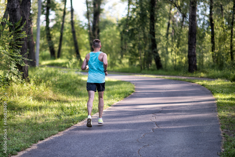 A running sportsman in a park on summer morning. A running sportsman in a park on summer morning.