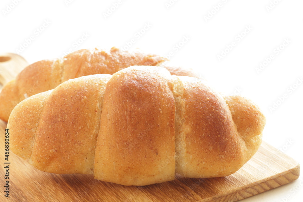 Homemade salt on butter roll bun on wooden bread board for breakfast 