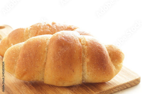 Homemade salt on butter roll bun on wooden bread board for breakfast 