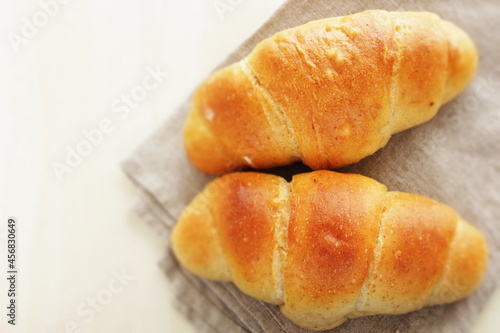 Homemade salt on butter roll bun on wooden bread board for breakfast  © jreika
