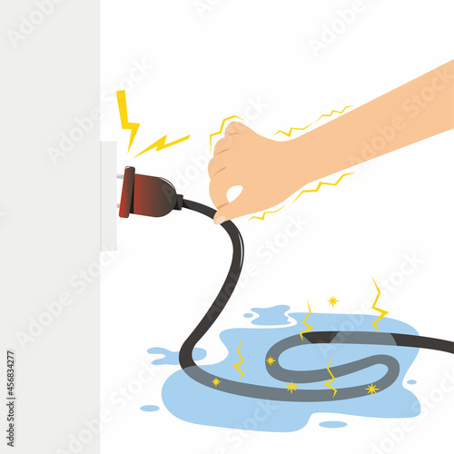Hand holding wet electrical cable with sparks.