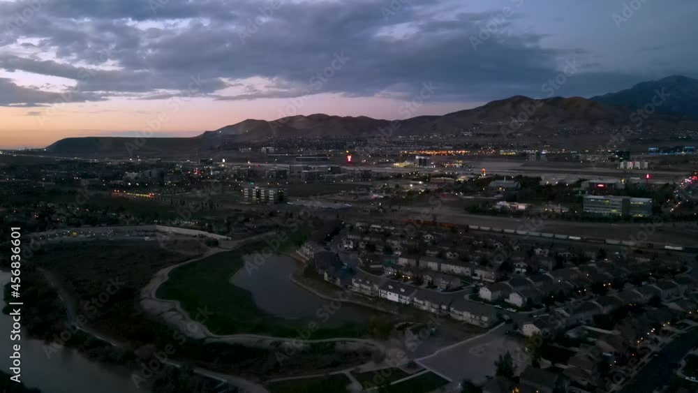 A train passes through Lehi, Utah and Silicon Slope at dusk - push in descending aerial view A train passes through Lehi, Utah and Silicon Slope at dusk - push in descending aerial view