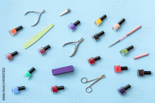 Set of tools for manicure and nail polishes on color background
