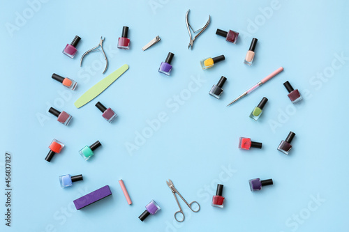 Frame made of tools for manicure and nail polishes on color background