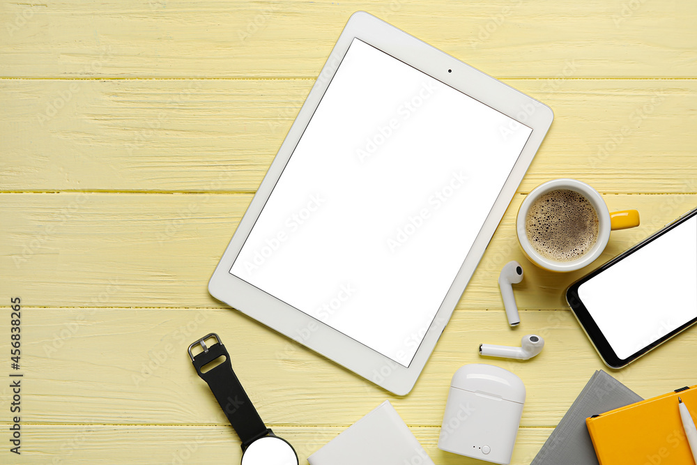 Different modern devices and cup of coffee on color wooden background Different modern devices and cup of coffee on color wooden background