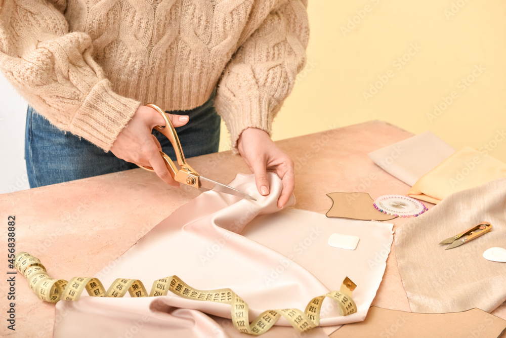 Woman cutting fabric at table