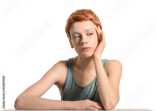 Teenage boy with dyed eyebrows on white background