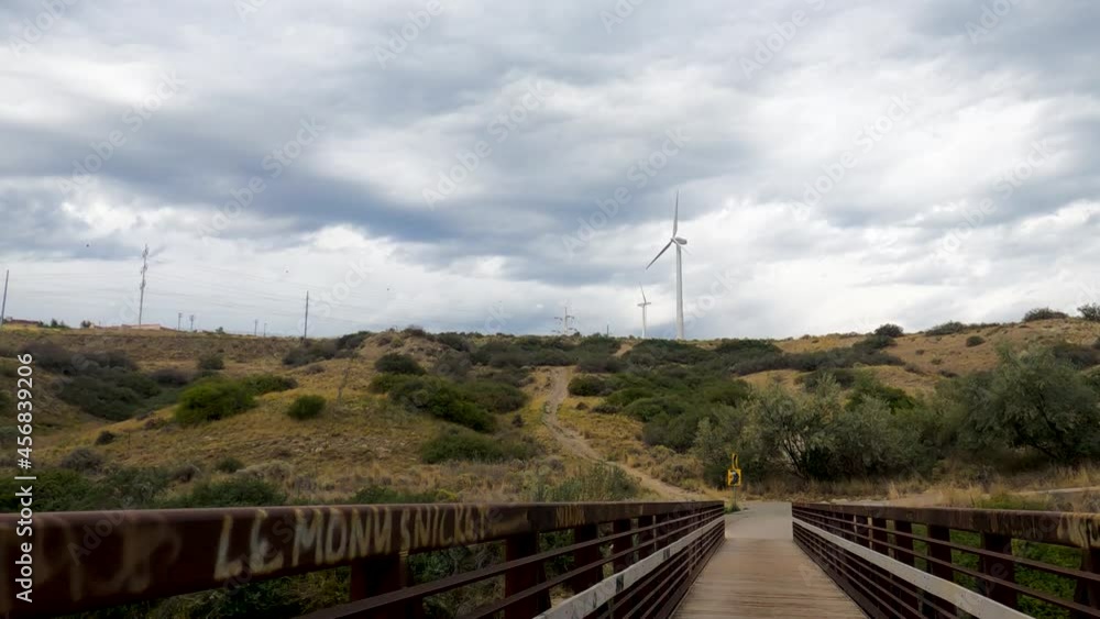 Cycling across a bridge over a river on an overcast summer day