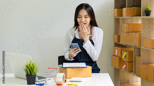 young businesswoman working at home on online business Women business owners use laptops to work at home and start an SME business. Small and cardboard boxes at the workplace