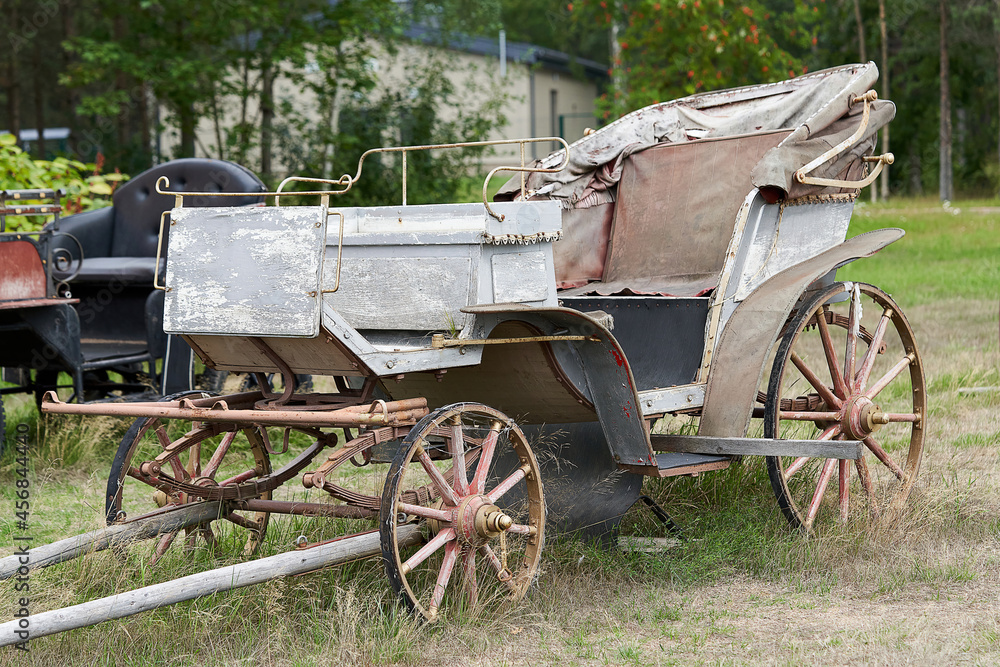 Old carriage in a rural courtyard on a summer day