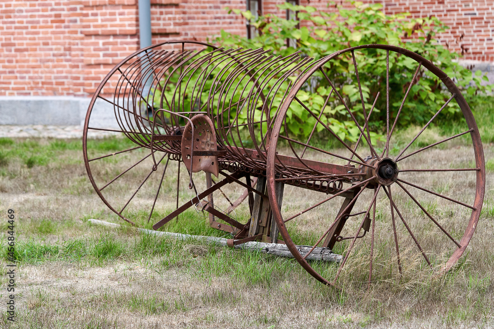 Old agricultural machinery with large wheels in a rural yard Old agricultural machinery with large wheels in a rural yard