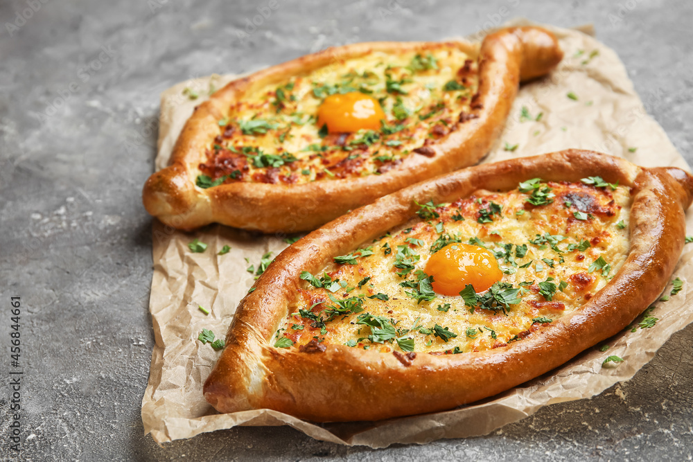 Tasty Ajarian khachapuri on grunge background